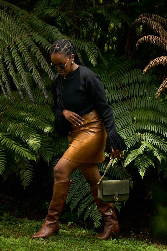 Black knit fringe sweater styled with brown leather skirt,brown leather boots and a green suede bag