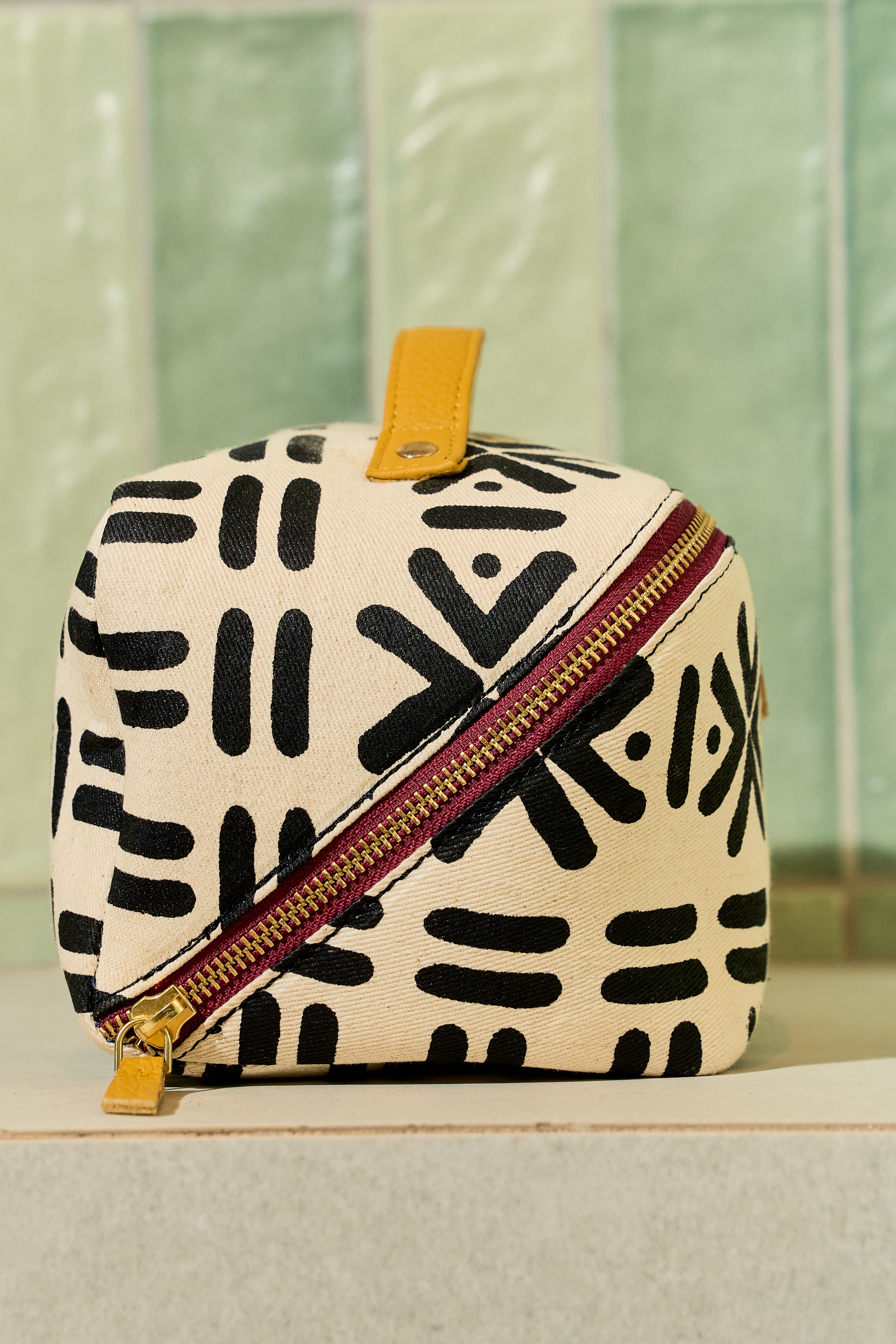 Zola toiletry bag side profile showing structured shape and leather zipper pull