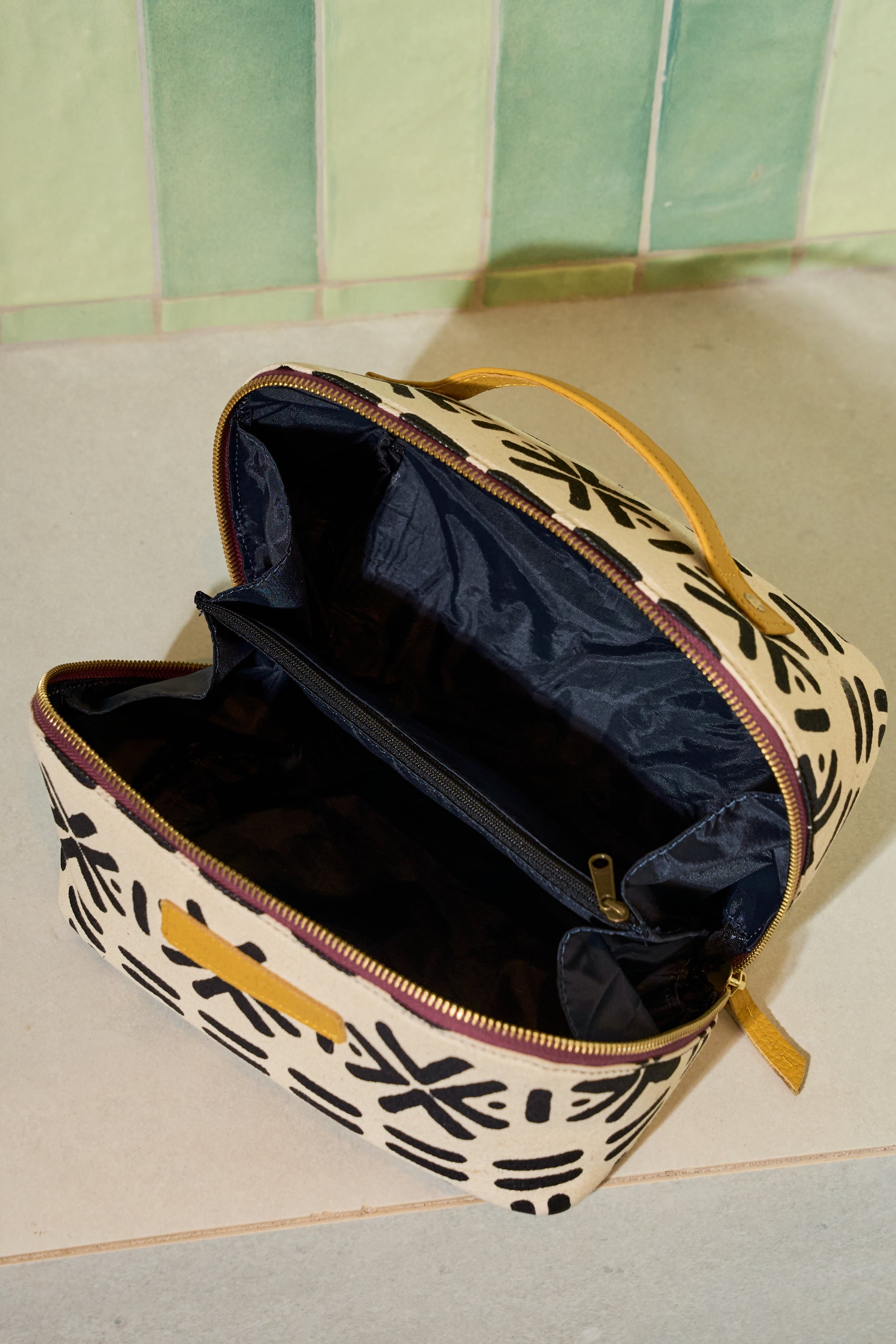 Zola toiletry bag open to reveal waterproof and spill proof navy lining and four interior pocket sleeves